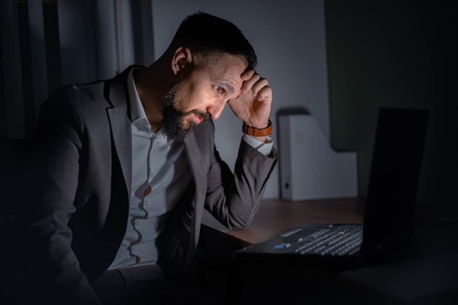 Man stressed at work - Overtime Violations